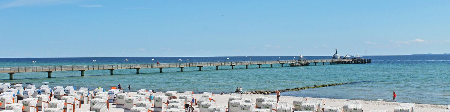 Ausblick von der Grömitzer Welle auf die Ostsee mit Strandkörben und Seebrücke