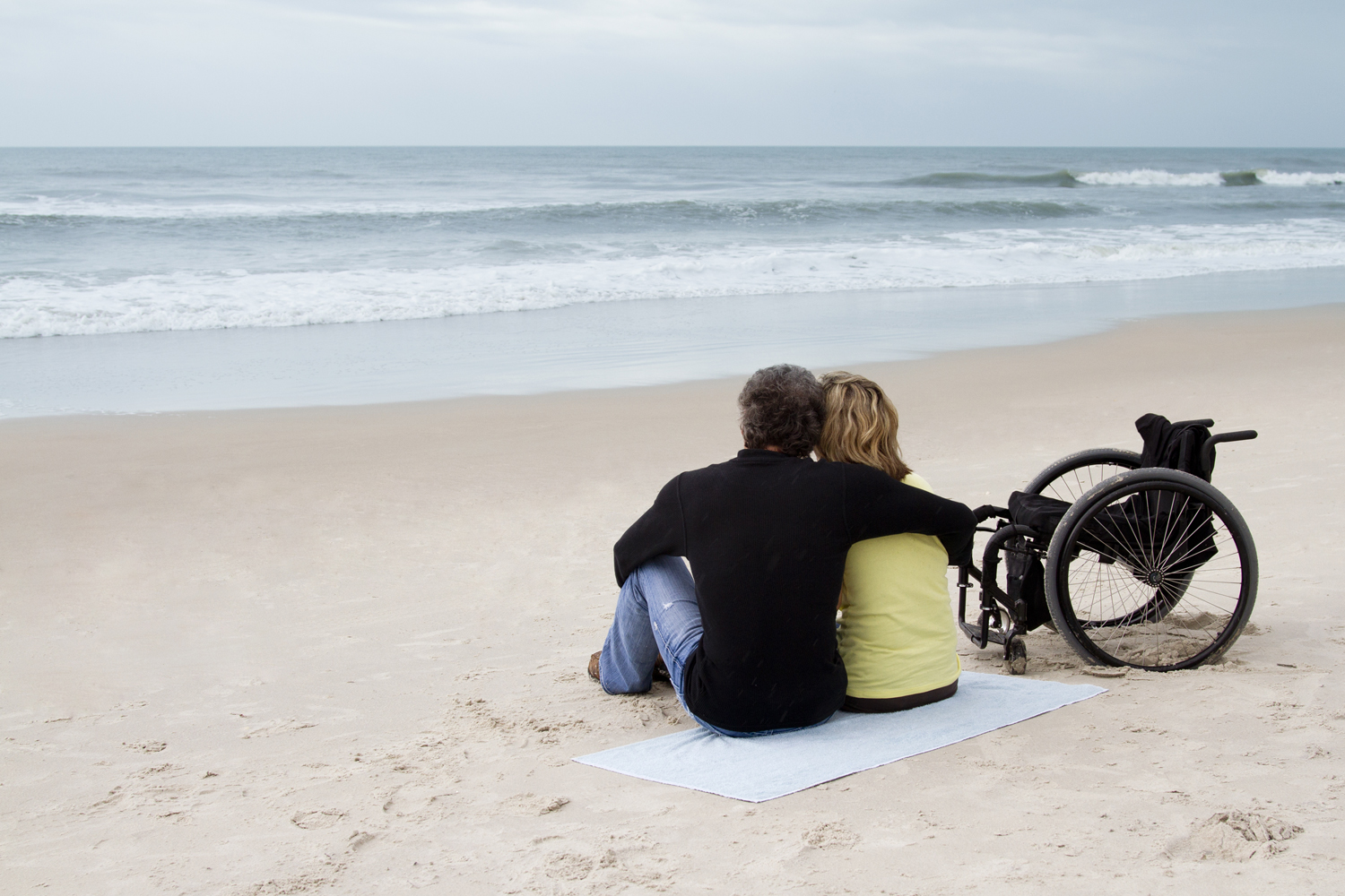 Pärchen mit Rollstuhl am Strand